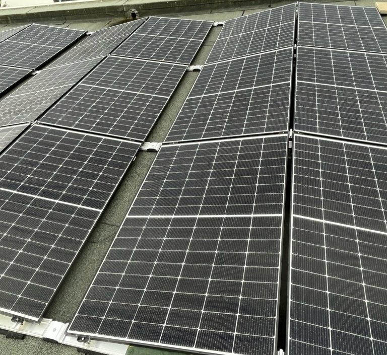 Dach mit mehreren Solarmodulen in einem geraden Muster. Flachdachmontage.